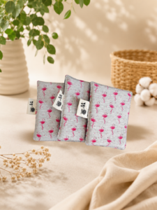 Lot de lingettes lavables rectangulaires avec motif flamants roses sur tissu gris clair, confectionnées artisanalement.