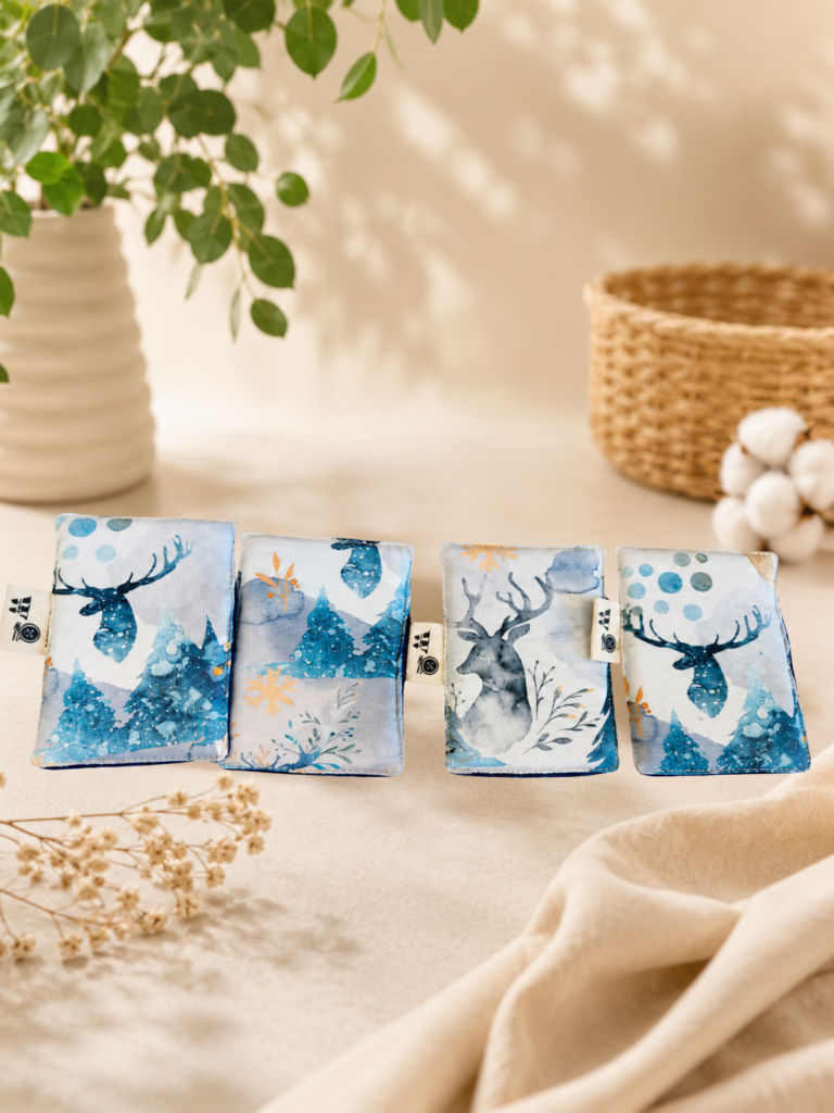 Lot de lingettes lavables rectangulaires artisanales avec motif cerf bleu et imprimé hivernal sur fond clair.